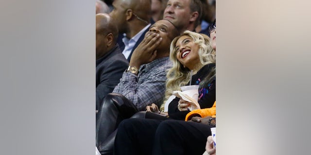 Jay-Z, left, and Beyonce look up at the scoreboard during an NBA basketball game between the Oklahoma City Thunder and the Los Angeles Clippers in Oklahoma City, Thursday, Nov. 21, 2013. (AP Photo/Sue Ogrocki)