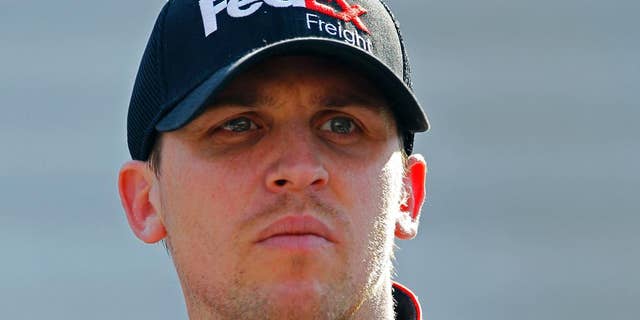 FILE - In this April 18, 2015, file photo, Driver Denny Hamlin looks at the time tower during practice for the NASCAR Sprint Cup Series auto race at Bristol Motor Speedway in Bristol, Tenn. Denny Hamlin will be back behind the wheel of his car this weekend at Richmond International Raceway, where he'll try to shine at his hometown track. His week begins early with his Short Track Showdown exhibition race, and he said the neck spasms that forced him out of the car last weekend have been addressed.  (AP Photo/Wade Payne, File)