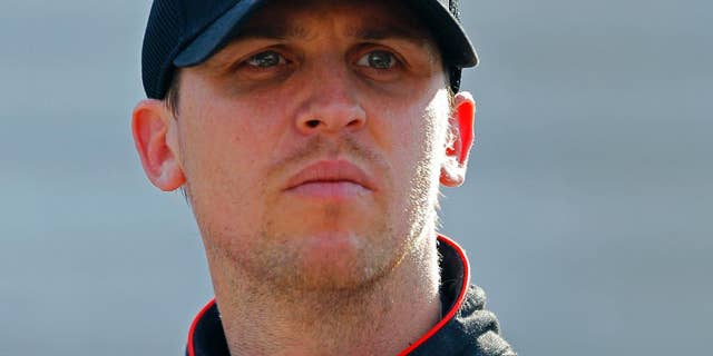 FILE - In this April 18, 2015, file photo, Driver Denny Hamlin looks at the time tower during practice for the NASCAR Sprint Cup Series auto race at Bristol Motor Speedway in Bristol, Tenn. Denny Hamlin will be back behind the wheel of his car this weekend at Richmond International Raceway, where he'll try to shine at his hometown track. His week begins early with his Short Track Showdown exhibition race, and he said the neck spasms that forced him out of the car last weekend have been addressed. (AP Photo/Wade Payne, File)