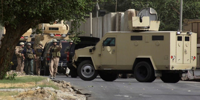 June 6: Security contractors inspect their armored vehicles after a roadside bomb attack in Baghdad, Iraq.