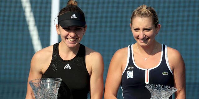 Simona Halep of Romania, left, and Timea Bacsinszky of Switzerland pose with their trophies after their final match of the WTA Shenzhen Open tennis tournament in Shenzhen in southern China's Guangdong province Saturday, Jan. 10, 2015. Halep beat Bacsinszky 2-0 in the final. (AP Photo) CHINA OUT