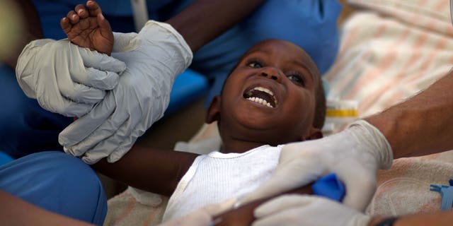 A child with cholera symptoms is treated by volunteer American doctors at a hospital in Archaie, Haiti, Monday Nov. 15, 2010. Nearly 1,000 people have been killed and thousands have been hospitalized for cholera across Haiti, with symptoms including serious diarrhea, vomiting and fever. (AP Photo/Ramon Espinosa)
