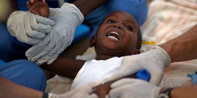 A child with cholera symptoms is treated by volunteer American doctors at a hospital in Archaie, Haiti, Monday Nov. 15, 2010. Nearly 1,000 people have been killed and thousands have been hospitalized for cholera across Haiti, with symptoms including serious diarrhea, vomiting and fever. (AP Photo/Ramon Espinosa)
