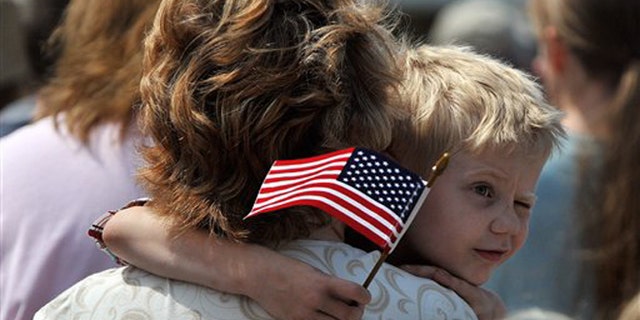 FILE -- Monday, May 28, 2012: Austin Bunyard, 5, squints in the bright sun as he watches veterans salute the American flag during a Memorial Day ceremony on the Rock Island Arsenal in Rock Island, Ill.