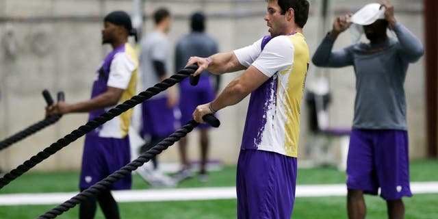 Minnesota Vikings quarterback Christian Ponder, right, and wide receiver Jerome SImpson, left, work on a rope pull exercise during conditioning workouts for the NFL football team, Wednesday, May 1, 2013 in Eden Prairie, Minn. Uncovering his head to watch is wide receiver Greg Jennings, right. (AP Photo/Jim Mone)