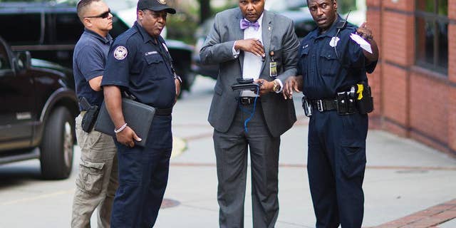 Authorities speak outside Ebenezer Baptist Church where Confederate flags were found Thursday, July 30, 2015, in Atlanta. U.S. authorities are investigating after several Confederate battle flags were discovered near the church and a civil rights center named after Martin Luther King, an iconic leader in the African-American Civil Rights Movement, Thursday morning. (AP Photo/David Goldman)