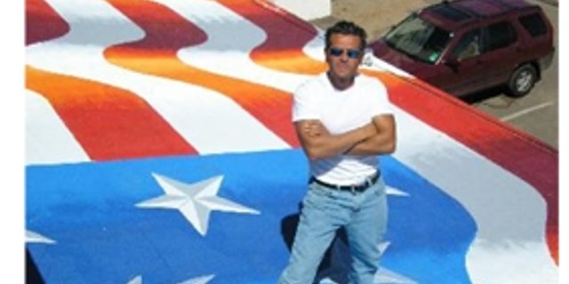 Artist Scott LoBaido showcasing his flag painting on a rooftop in Pioria, Ariz.
