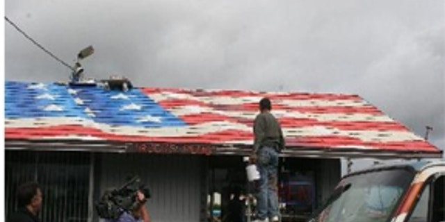 Artist Scott LoBaido's flag painting on a rooftop in Everett, Wash.