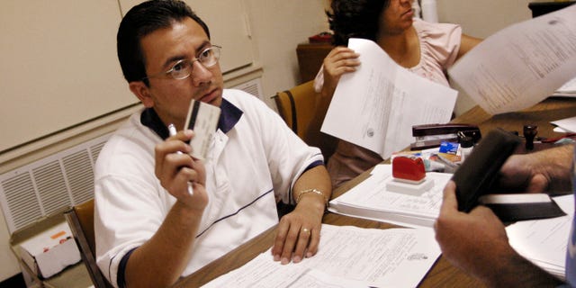 LONGVIEW, TX - JULY 24: Salvador Alanis (L), a Mexican Consulate official, asks to see proper Mexican and American identifications documents from an Mexican citizen applying for the ?Matricula Consular? card, at the Wesley-McCabe United Methodist Church July 24, 2004 in Longview, Texas. The identification card is issued to Mexican citizens living outside of Mexico to recognize legitimate Mexicans in the U.S. Mexican Consulate officials from Dallas, Texas established what they called a ?mobile consulate? in Longview to process applicants from 450 Mexican citizens. (Photo by Mario Villafuerte/Getty Images)