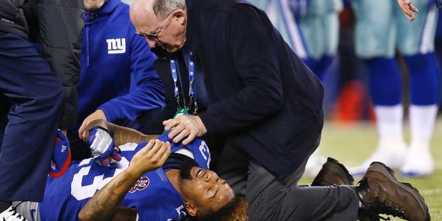 New York Giants wide receiver Odell Beckham Jr. (13) is tended to by trainers after taking a hit in the back against the Dallas Cowboys during the fourth quarter of an NFL football game, Sunday, Nov. 23, 2014, in East Rutherford, N.J. (AP Photo/Kathy Willens)