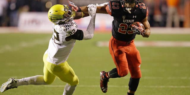 Oregon linebacker Derrick Malone (22) attempts to make a tackle as Utah running back Devontae Booker (23) carries the ball in the second quarter during an NCAA college football game Saturday, Nov. 8, 2014, in Salt Lake City. (AP Photo/Rick Bowmer)