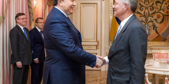 Ukraine's President Viktor Yanukovych, left, greets United Nations Special Coordinator Robert Serry prior their talks in Kiev, Ukraine, Wednesday, Jan. 29, 2014. Ukraine's parliament discussed an amnesty Wednesday for those arrested during weeks of protests in the crisis-torn country — but some of the possible conditions attached to it would be unacceptable to the opposition. (AP Photo/Mykhailo Markiv, Pool)
