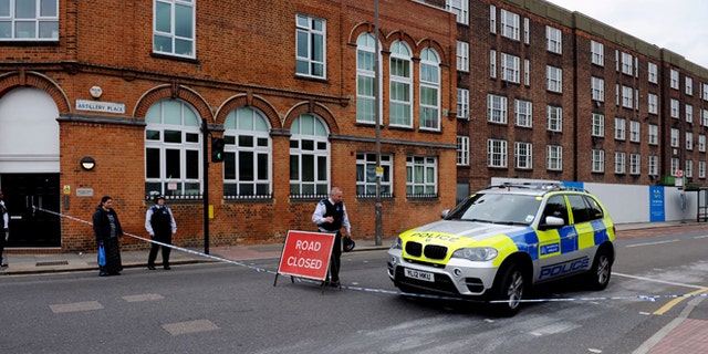 May 22, 2013: Police close the road on Artillery Place, Woolwich southeast London near the scene where British officials said one person has died and at least two people have been wounded in an attack.