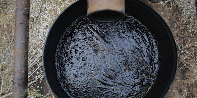 In this Friday, May 13, 2016, photo, an overflow barrel holds oil near a storage tank on a South Texas ranch near Bigfoot, Texas. The agencies that regulate the oil and gas industry are running out of money just as some problems in the oilfields are worsening. Meanwhile, defunct companies are abandoning wells that are in danger of deteriorating. (AP Photo/Eric Gay)