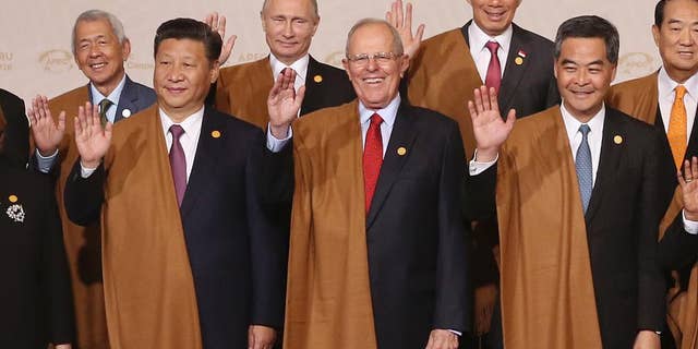 From left, Philippines's Secretary of Department of Foreign Affairs Perfecto Yasay, China's President Xi Jinping, Russia's President Vladimir Putin, Peru's President Pedro Kuczynski, Singapore's Prime Minister Lee Hsien Loong, Hong Kong's Chief Executive Leung Chun-ying and Taiwan 's special APEC envoy James Soong wave during the group photo at the annual Asia Pacific Economic Cooperation, APEC, summit in Lima, Peru, Sunday, Nov. 20, 2016. (AP Photo/Martin Mejia)