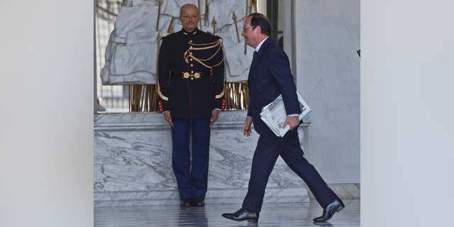 French President Francois Hollande walks through the lobby of the Elysee Palace in Paris, France, after the weekly cabinet meeting Wednesday, Aug. 26, 2015. (AP Photo/Michel Euler)