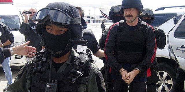 FILE: Russian arms trafficker Viktor Bout, right, escorted by Thai police commandos, arrives at Don muang airport in Bangkok .