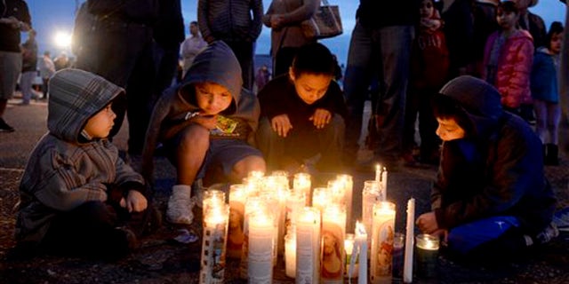 Pasco, Wash., residents, from left foreground to right, Angel Morgan, 5, and his brother Jose Morgan, 6, as well as Alex Gonzalez, 4, and his brother Angel Gonzalez, 8, gather around a candlelit vigil Wednesday, Feb. 11, 2015, in memory of Antonio Zambrano-Montes who was fatally shot by police after a confrontation on Tuesday. (AP Photo/The Tri-City Herald, Sarah Gordon) LOCAL TELEVISION OUT; LOCAL RADIO OUT KONA