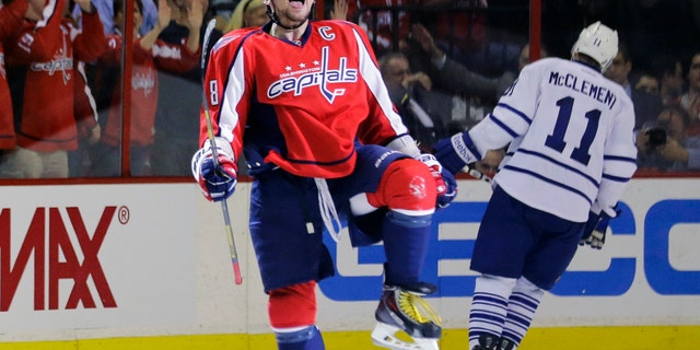 Washington Capitals left wing Alex Ovechkin (8), from Russia, celebrates his goal as Toronto Maple Leafs center Jay McClement (11) skates behind in the second period of an NHL hockey game Tuesday, April 16, 2013 in Washington. (AP Photo/Alex Brandon)