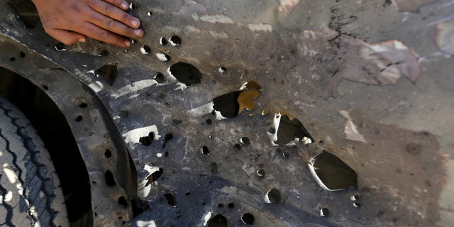 Palestinian Hamas security officers and civilians inspect the debris of a damaged motorcycle after an Israeli airstrike in Deir al-Balah, central Gaza Strip, Sunday, Feb. 9, 2014. The Israeli military says it has carried out an airstrike in the Gaza Strip targeting a Palestinian militant, Abdallah Kharti, who it says is affiliated with the Popular Resistance Committees militant group, and that Kharti planned and carried out numerous rocket attacks on Israel. A Gaza health official says the targeted man was critically wounded. (AP Photo/Hatem Moussa)