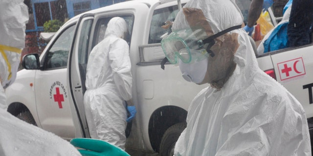 Health workers dressed in protective gear prepare to load the body of a woman suspected to have died from Ebola virus, in New Kru Town at the outskirt of Monrovia, Liberia, Wednesday, Oct. 8, 2014. Liberia has been among the hardest hit nations at the centre of the long outbreak, which has killed more than 3,000 people, as of Friday, there had been 3,834 confirmed Ebola cases and 2,069 deaths in Liberia, according to the World Health Organization. Forty-four percent of the Ebola cases were reported in the past three weeks, a signal that the infectious disease is spreading.(AP Photo/Abbas Dulleh)