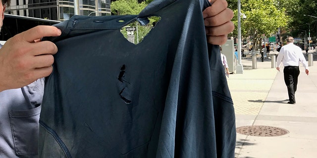 Lee with the shirt he says was torn when he was removed from the U.N. by security.