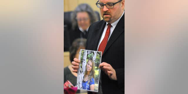 FILE - In this Feb. 23, 2015 file photo, Assistant Attorney Gen. Donald Macomber hold up a picture of Nichole Cable during opening arguments on the first day of Kyle Dube's trial in Bangor, Maine, where he was charged in Cable's 2013 kidnapping and murder. After less than an hour of deliberation, a jury convicted Dube Friday, March 6, 2015, of using a bogus Facebook profile to lure Cable to her death in a botched plot to look like a hero. (AP Photo/The Bangor Daily News, Gabor Degre, Pool, File)