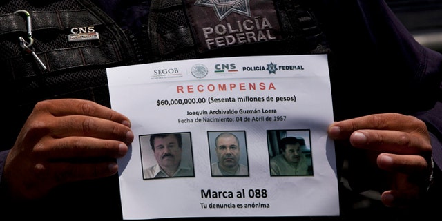 In this July 16, 2015, photo, a Federal Police shows a reward notice for information leading to the capture of drug lord Joaquin "El Chapo" Guzman, who made his escape from the Altiplano maximum security prison via an underground tunnel,  in Almoloya, west of Mexico City. The Drug Enforcement Administrations deputy administrator says he is confident one of the worlds most-wanted drug traffickers will be captured again after a brazen weekend escape from a maximum-security Mexican prison.  (AP Photo/Marco Ugarte)