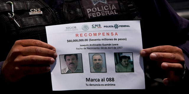 In this July 16, 2015, photo, a Federal Police shows a reward notice for information leading to the capture of drug lord Joaquin "El Chapo" Guzman, who made his escape from the Altiplano maximum security prison via an underground tunnel, in Almoloya, west of Mexico City. The Drug Enforcement Administrations deputy administrator says he is confident one of the worlds most-wanted drug traffickers will be captured again after a brazen weekend escape from a maximum-security Mexican prison. (AP Photo/Marco Ugarte)