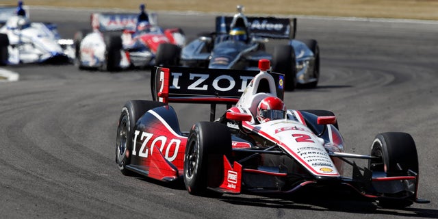 A.J. Allmendinger (2) leads a pack of cars into Turn 17 during the IndyCar Series Grand Prix of Alabama auto race in Birmingham, Ala., Sunday, April 7, 2013. (AP Photo/Butch Dill)