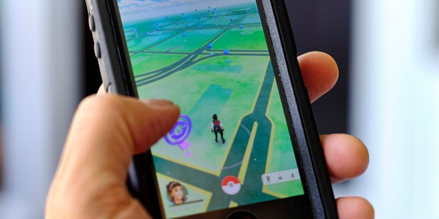 Pokemon Go is displayed on a cell phone in Los Angeles on Friday, July 8, 2016. Just days after being made available in the U.S., the mobile game Pokemon Go has jumped to become the top-grossing app in the App Store. And players have reported wiping out in a variety of ways as they wander the real world, eyes glued to their smartphone screens, in search of digital monsters. (AP Photo/Richard Vogel)