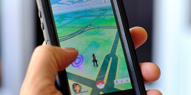 Pokemon Go is displayed on a cell phone in Los Angeles on Friday, July 8, 2016. Just days after being made available in the U.S., the mobile game Pokemon Go has jumped to become the top-grossing app in the App Store. And players have reported wiping out in a variety of ways as they wander the real world, eyes glued to their smartphone screens, in search of digital monsters. (AP Photo/Richard Vogel)