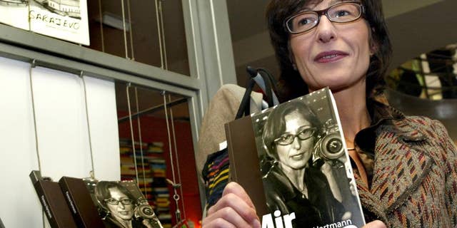FILE - In this Tuesday, Nov. 13, 2007 file photo, Florence Hartmann, ex-spokeswoman for the Chief Prosecutor of the Hague-based International Criminal Tribunal for the former Yugoslavia (ICTY), presents her book Peace and Punishment in Sarajevo. Florence Hartmann, U.N. spokeswoman-turned-whistleblower, is behind bars at the same prison complex with many of the war criminals she spent her career trying to expose, her lawyer said Monday March 28, 2016, as journalists and victims’ advocates rallied to her side. (AP Photo/Hidajet Delic, File)