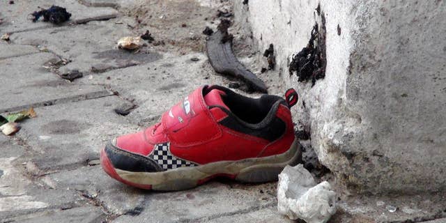 The shoe of a young victim and a piece of metal lay near the scene just hours after Saturday's bomb attack in Gaziantep, Turkey.
