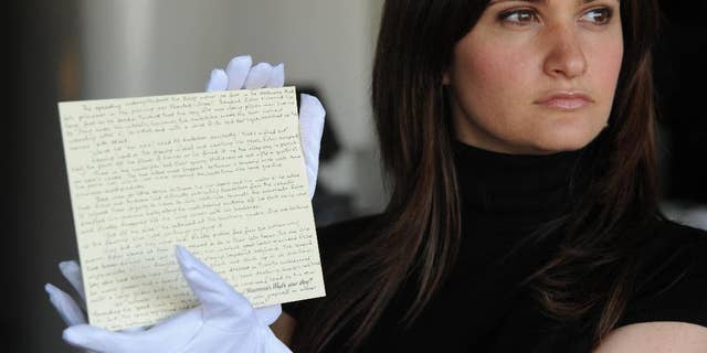 FILE - In this June 10, 2008 file photo, a member of staff at Waterstones holds a story written by JK Rowling donated by the author, for the What's Your Story? auction in aid of English PEN and Dyslexia Action, in London. West Midlands Police said Friday May 12, 2017, that the handwritten Harry Potter prequel has been stolen along with some jewelry, during a burglary in Birmingham, central England between April 13 and 24. (Joel Ryan/PA via AP, File)