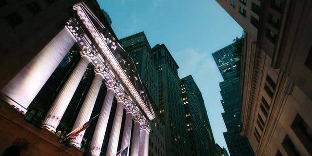 FILE - In this Oct. 8, 2014 file photo, American flags fly in front of the New York Stock Exchange, in New York. Stocks are little changed in early trading Monday, Nov. 3, 2014, as investors brace for a busy week of news. (AP Photo/Mark Lennihan, File)