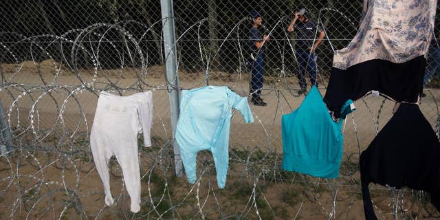 Clothes are placed on a fence to dry at the Horgos border crossing into Hungary, near Horgos, Serbia, Wednesday, Sept. 16, 2015. Small groups of migrants continued to sneak into Hungary on Wednesday, a day after the country sealed its border with Serbia and began arresting people trying to breach the razor-wire barrier, while a first group arrived in Croatia seeking another way into the European Union. (AP Photo/Darko Vojinovic)