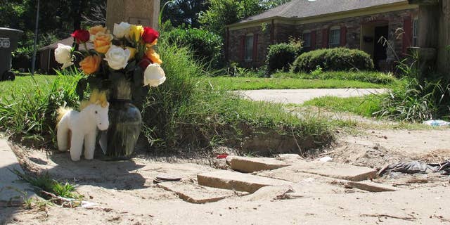 A makeshift memorial rests on the sidewalk Monday, Aug. 3, 2015, at the location where Memphis, Tenn., Police Officer Sean Bolton was fatally shot. Tremaine Wilbourn, the ex-con accused of killing the Memphis Police Officer turned himself into federal authorities Monday, after a two-day manhunt. (AP Photo/Adrian Sainz)