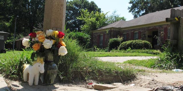 A makeshift memorial rests on the sidewalk Monday, Aug. 3, 2015, at the location where Memphis, Tenn., Police Officer Sean Bolton was fatally shot. Tremaine Wilbourn, the ex-con accused of killing the Memphis Police Officer turned himself into federal authorities Monday, after a two-day manhunt. (AP Photo/Adrian Sainz)