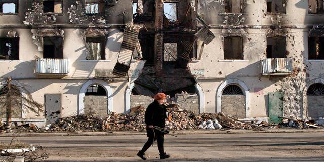 March 9, 2015: An elderly woman walks by a destroyed building in Vuhlehirsk, Ukraine.