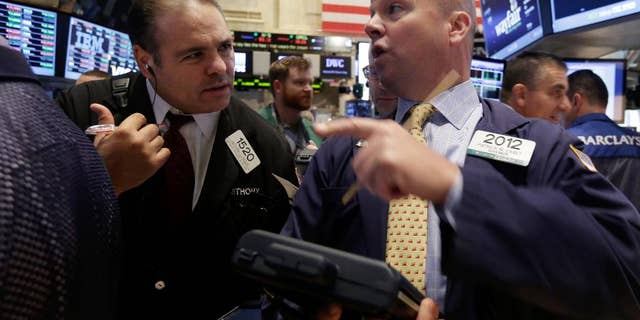 Traders Anthony Riccio, left, and Patrick Casey work on the floor of the New York Stock Exchange, Thursday, Oct. 2, 2014. U.S. markets were mostly flat in early trading Thursday, follow a sell-off the day before, as U.S. investors had little reaction to comments from European Central Bank President Mario Draghi, who announced new economic stimulus measures for the continent. (AP Photo/Richard Drew)