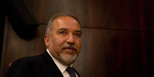 FILE -- In this May 30, 2016 file photo, Israeli Defense Minister Avigdor Lieberman walks at the Knesset, Israel's parliament, ahead of his swearing-in ceremony in Jerusalem. Lieberman's office said Tuesday, July 12, 2016, that it has blocked an Israeli delegation from traveling to the West Bank to meet with the Palestinian president on political grounds. The office said it refused to allow the activists to travel to Ramallah Monday because the Palestinian side included Mohammed al-Madani, an aide to President Mahmoud Abbas who oversees outreach to Israeli society, who Lieberman has accused al-Madani of “subversive activities.” (AP Photo/Ariel Schalit, File)