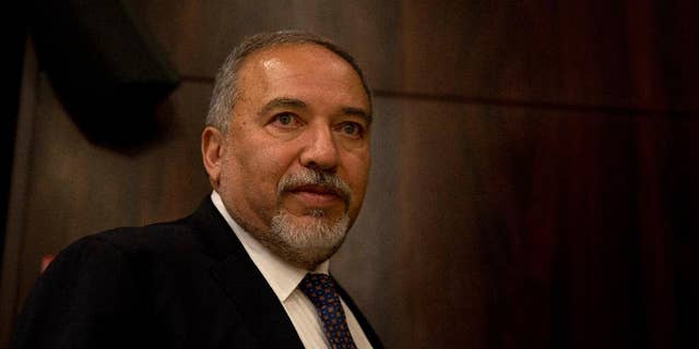 FILE -- In this May 30, 2016 file photo, Israeli Defense Minister Avigdor Lieberman walks at the Knesset, Israel's parliament, ahead of his swearing-in ceremony in Jerusalem. Lieberman's office said Tuesday, July 12, 2016, that it has blocked an Israeli delegation from traveling to the West Bank to meet with the Palestinian president on political grounds. The office said it refused to allow the activists to travel to Ramallah Monday because the Palestinian side included Mohammed al-Madani, an aide to President Mahmoud Abbas who oversees outreach to Israeli society, who Lieberman has accused al-Madani of “subversive activities.” (AP Photo/Ariel Schalit, File)