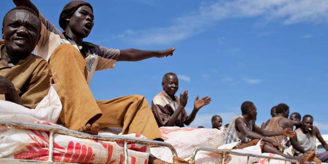 FILE - In this Sunday Sept. 16, 2012 file photo, South Sudanese men sing and clap as they ride on the truck carrying WFP food supplies to a warehouse, in Yida camp, South Sudan. The World Food Program said Friday April 14, 2017 it is "horrified" to learn that three of its South Sudan workers were killed this week in violence in the western town of Wau, as the country's civil war continues under warnings of possible genocide. (AP Photo/Mackenzie Knowles-Coursin, File)