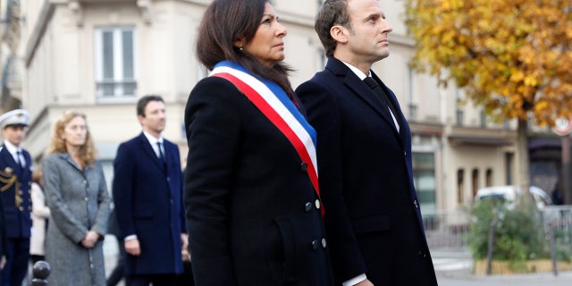 French President Emmanuel Macron and Paris mayor Anne Hidalgo, left, stand in front of a commemorative plaque facing the 'Le Carillon' bar and 'Le Petit Cambodge' restaurant during a ceremony marking the second anniversary of the Paris attacks, Monday Nov.13 2017