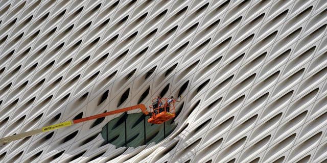 FILE - In this Sept. 1, 2015 file photo, workers clean the facade around a window of the new Broad Museum in downtown Los Angeles. The Conference Board releases its index of leading indicators for August on Friday, Sept. 18, 2015. (AP Photo/Richard Vogel, File)
