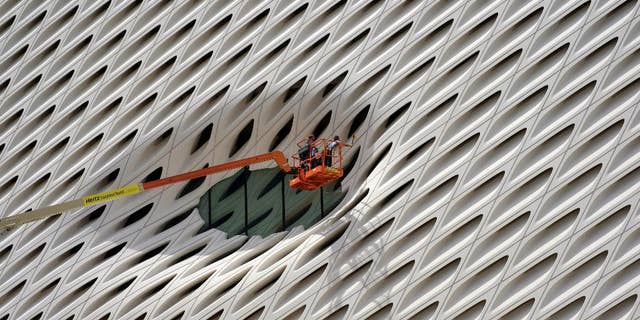 FILE - In this Sept. 1, 2015 file photo, workers clean the facade around a window of the new Broad Museum in downtown Los Angeles. The Conference Board releases its index of leading indicators for August on Friday, Sept. 18, 2015. (AP Photo/Richard Vogel, File)
