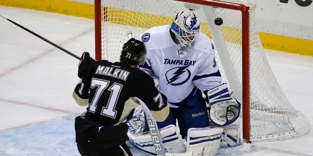 Pittsburgh Penguins' Evgeni Malkin (71) backhands a shot over Tampa Bay Lightning goalie Anders Lindback (39) for a goal in the third period of an NHL hockey game in Pittsburgh, Saturday, March 22, 2014. The Penguins won 4-3 in overtime. (AP Photo/Gene J. Puskar)