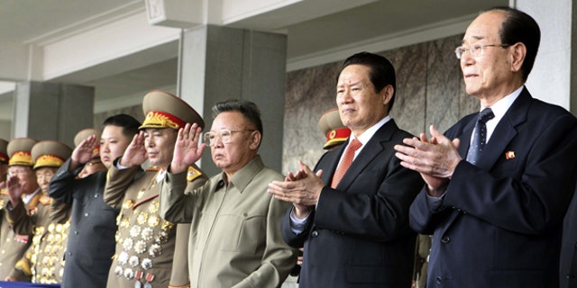 Oct. 10: In this photo released by China's Xinhua News Agency, Kim Jong Un, fourth from left, salutes while standing with his father North Korean leader Kim Jong Il, center and Zhou Yongkang, second from right, a member of the Standing Committee of the Political Bureau of the Communist Party of China (CPC) Central Committee, as they watch a massive military parade to celebrate the 65th anniversary of the founding of the Workers' Party of Korea (WPK), in Pyongyang, North Korea.