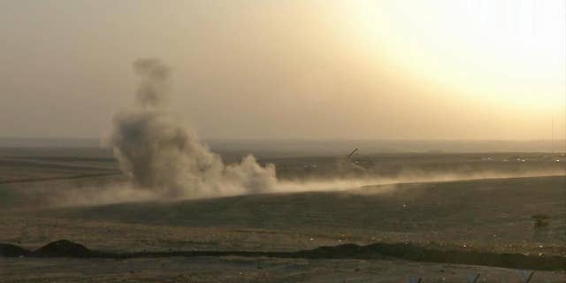 This image made from AP video shows smoke rising from airstrikes targeting Islamic State militants near the Khazer checkpoint outside of the city of Irbil in northern Iraq, Friday, Aug. 8, 2014. The Iraqi Air Force has been carrying out strikes against the militants, and for the first time on Friday, U.S. war planes have directly targeted the extremist Islamic State group, which controls large areas of Syria and Iraq.(AP Photo via AP video)